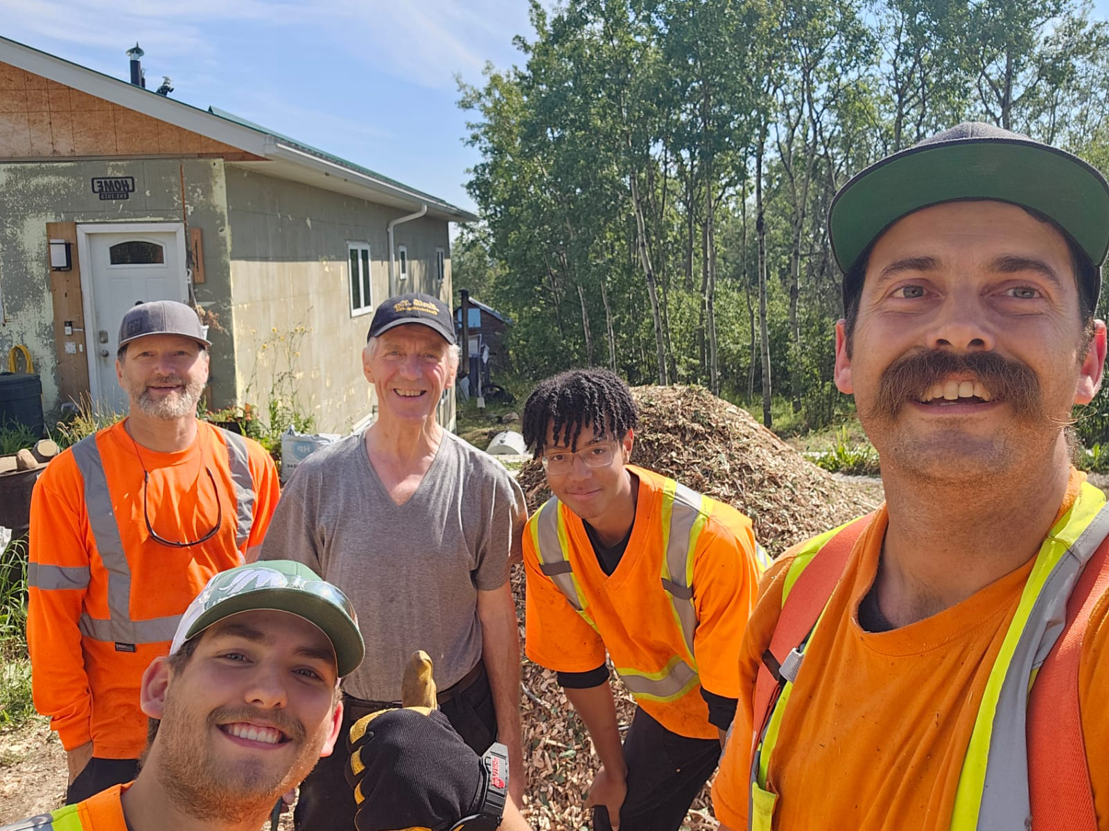 Mammoth Forestry crew with a satisfied resident after completing wildfire mitigation landscaping work as part of the advanced supports available through the PRRD FireSmart™ program. Peace River Regional District