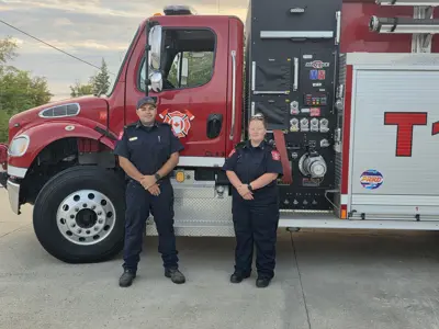 Lt. Chris Pelley and Lt. Miranda Moineau stand with Tactical Tender 1 prior to deploying to the Merritt area in support of BC Wildfire Service response efforts